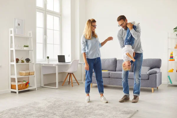 Mama, papa en zoontje hebben plezier thuis, genietend van het weekend in de lichte gezellige woonkamer. — Stockfoto