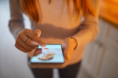Akıllı telefon tutan ve online flört uygulamasında erkek profili seçen kadın eller