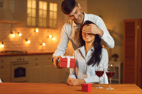 Married couple enjoying romantic date at home, exchanging presents and drinking wine