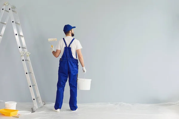 Empreiteiro pintor barbudo se preparando para pintar parede — Fotografia de Stock