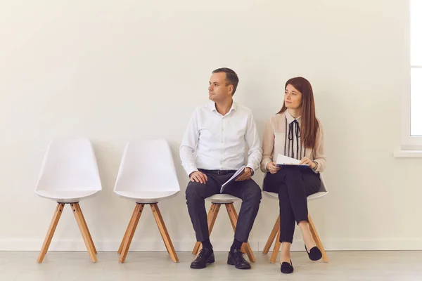 Självsäkra unga arbetssökande som sitter på stolar i hallen och väntar på sin intervju — Stockfoto