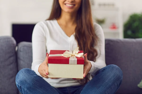 Smiling brunette girl holding holiday present box in hands during online dating — Stock Photo, Image