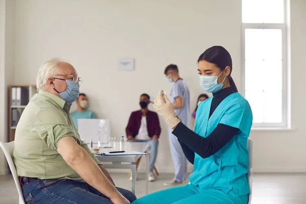 Oudere patiënt met gezichtsmasker wachtend op griep, longontsteking of Covid-19 vaccin — Stockfoto