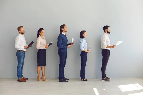 Giovani candidati a posti vacanti o in cerca di lavoro in fila con i curriculum e in attesa di un colloquio — Foto Stock