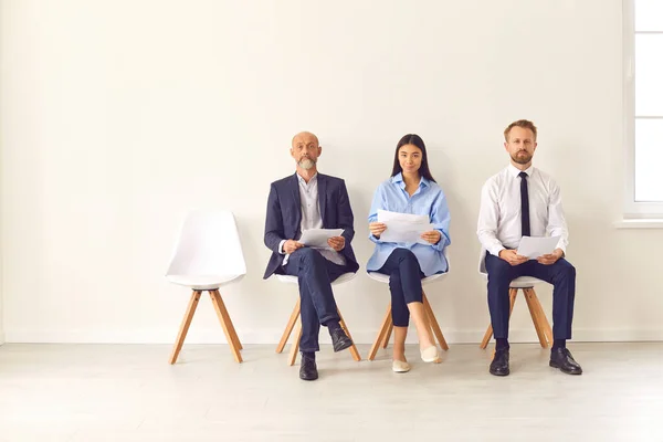 Gruppo di uomini d'affari seduti sulla sedia nella hall e in attesa di un colloquio. — Foto Stock