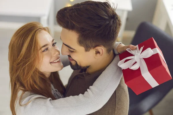 Joven pareja cariñosa abrazándose y mirándose durante los regalos y celebrando las vacaciones — Foto de Stock