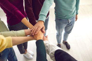 Yüksek açılı yakın çekim yapan bir grup insan ellerini birleştirip ortak bir amaç için birleşiyor.