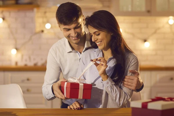 Joven bonita mujer desempacar regalo de vacaciones de su amante novio o marido — Foto de Stock