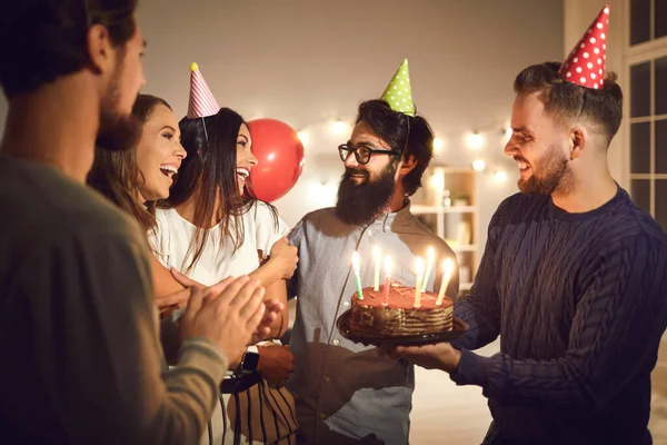 Smiling friends congratulating birthday girl with cake during celebration party — Stock Photo, Image