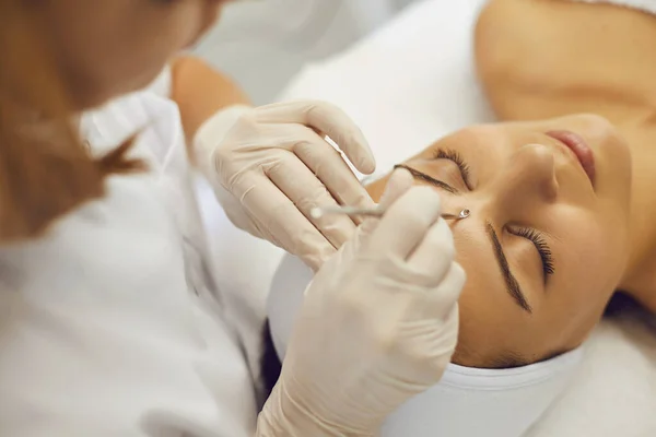 Cosmetologist profissional removendo cravos no rosto do cliente com a ajuda de ferramenta especial — Fotografia de Stock