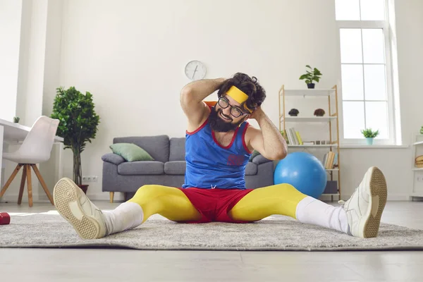 Cheerful funny man in colorful sportswear and glasses making sport workout at home