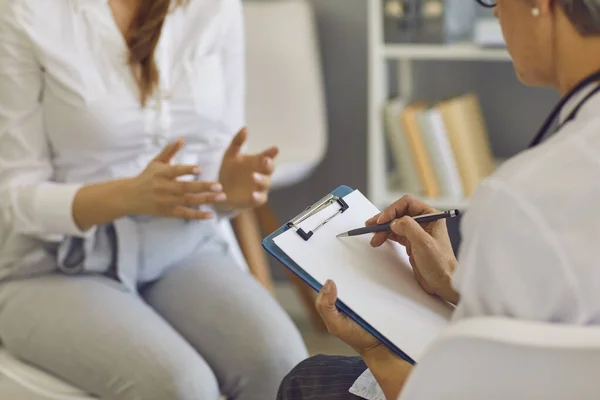 Primo piano della psicoterapeuta donna che scrive alcune informazioni sul suo paziente negli appunti. — Foto Stock