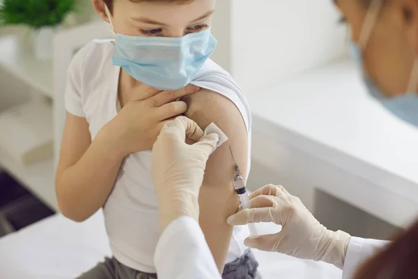 Boy in face mask getting flu shot at doctors office during World Immunization Week — Stock Photo, Image