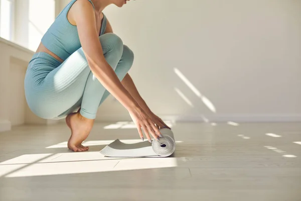 Çıplak ayaklı kız antrenman ya da yoga için spor halısı hazırlıyor. — Stok fotoğraf