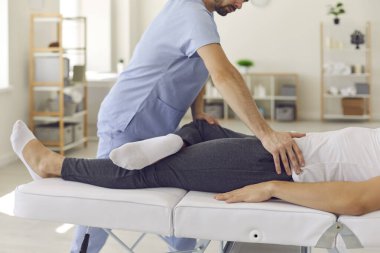 Kendine güvenen profesyonel doktor osteopat adam eklemleri onarmak için bacaklarını düzeltiyor.