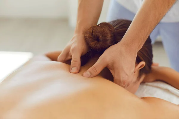 Jovem desfrutando de relaxante massagem corporal remedial feita por massagista profissional — Fotografia de Stock