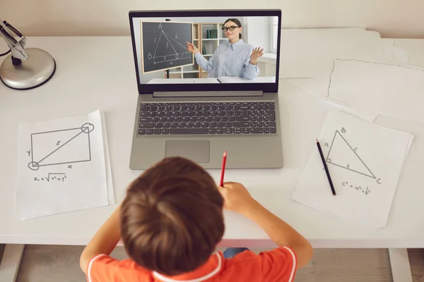 Boy gör anteckningar under online geometri lektion med lärare — Stockfoto