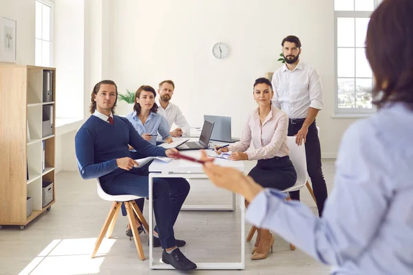 Gruppe von Büroangestellten sitzt und hört Kollegen zu, die Präsentationen im Büro machen — Stockfoto