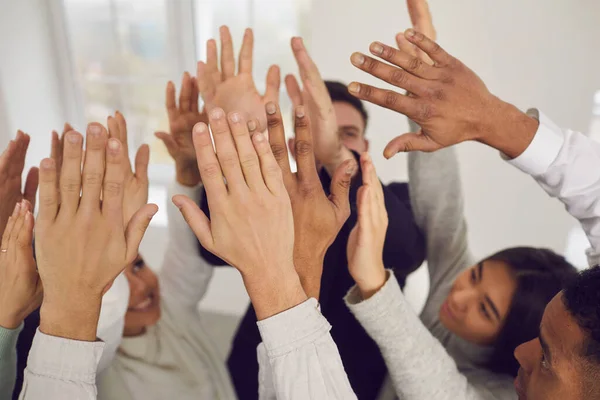 Equipe de jovens felizes mestiços de negócios levantando as mãos no ar — Fotografia de Stock
