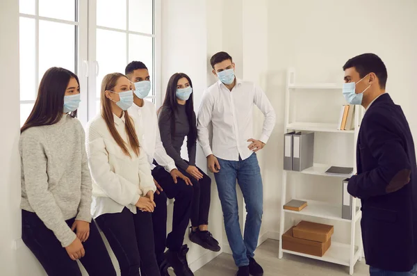 Group of college students in medical protective masks talk and discuss training during a break. — Stock Photo, Image