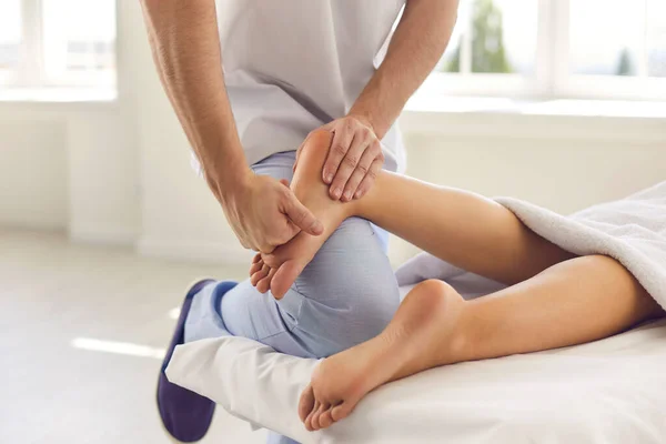 Cropped image of the hand of a male orthopedic doctor examining and massaging a patients foot. —  Fotos de Stock