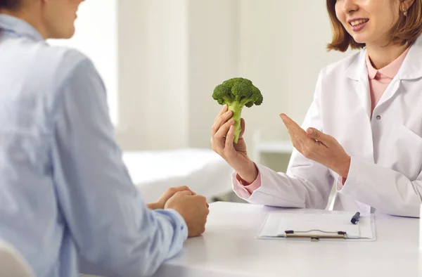 Nutritionist berätta för kvinnan om fördelarna med hälsosam kost och rekommendera att äta grönsaker — Stockfoto