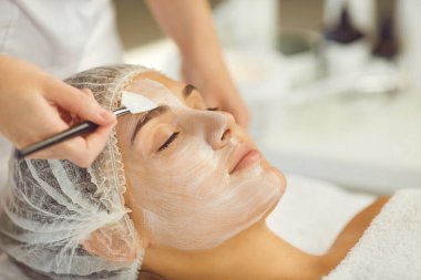 Kadın yüzü dinlendirici fırçayla nemlendirici maske takma prosedürü alınıyor