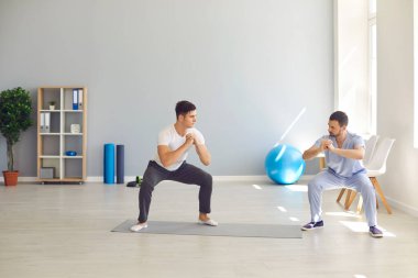 Osteopat, rehabilitasyon hareketlerini gösteriyor.