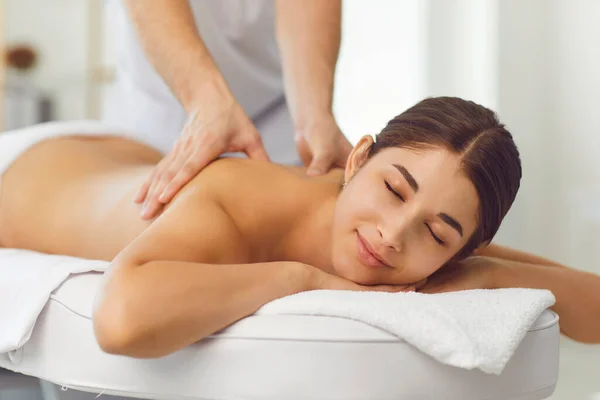 Happy relaxed woman receiving traditional therapeutic massage therapy in luxury spa. —  Fotos de Stock