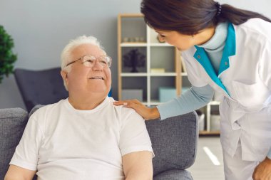 Dost canlısı doktor, kontrol etmek, desteklemek ve neşelendirmek için mutlu kıdemli adamı evinde ziyaret ediyor.