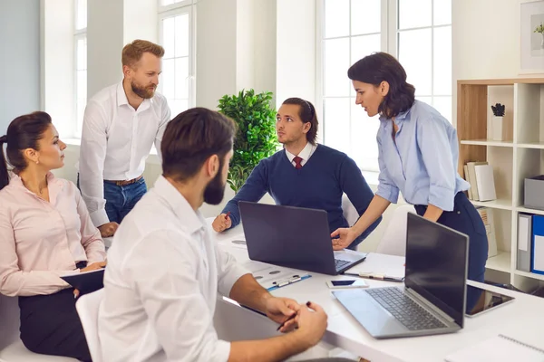 Gruppo di imprenditori di successo che discutono insieme un progetto intorno a una scrivania in ufficio. — Foto Stock