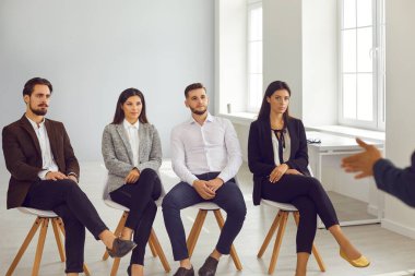 Eğitim seminerinde ya da personel eğitiminde sunum dinleyen ciddi gençler