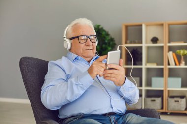 Son sınıf öğrencisi kafasında kulaklıkla video izliyor ve telefonla sosyal ağları tarıyor..