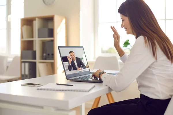 Smiling young business woman office worker in shirt sitting and greeting her director or partner online — Stock Photo, Image
