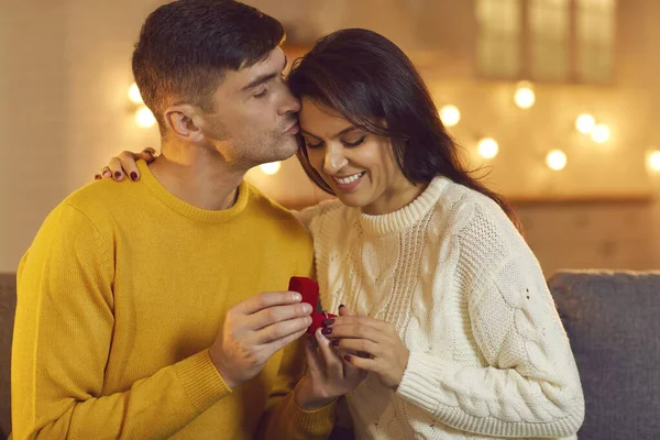 Homem beija uma mulher na testa mostrando-lhe um anel de casamento depois de uma proposta de casamento bem sucedida. — Fotografia de Stock