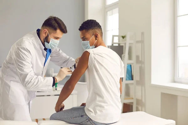 Junger Schwarzer erhält Impfung gegen COVID-19 vom Arzt — Stockfoto