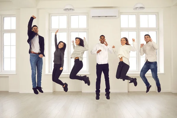 Grupo de colegas enérgicos felizes ou amigos pulando todos juntos e celebrando o sucesso — Fotografia de Stock