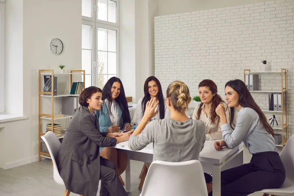 Smiling businesswomen sitting in circle at desk and planning projects together — Stock Photo, Image
