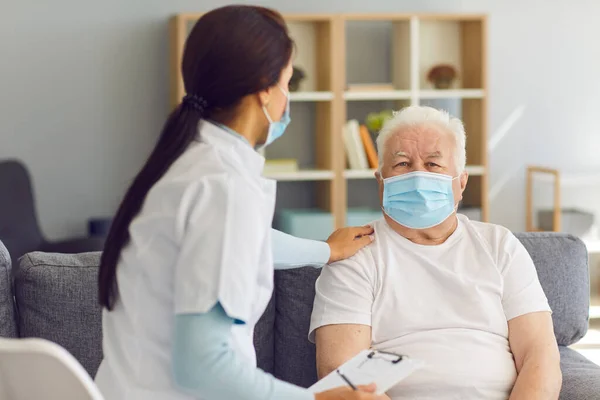 Dokter mengunjungi pasien senior di rumah, mendukungnya selama pandemi coronavirus — Stok Foto