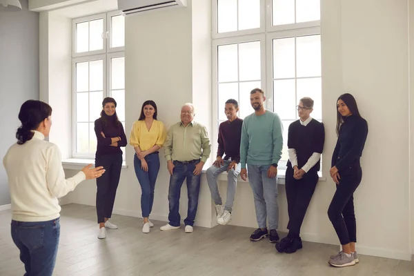 Grupp av leende blandras människor lyssnar på en tränare som ger ett intressant föredrag — Stockfoto