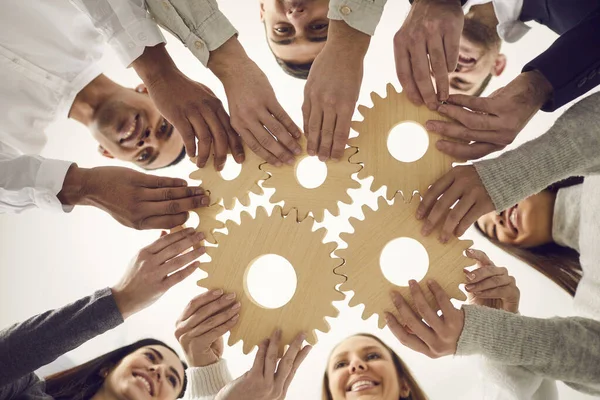 Het team van mensen voegt zich bij de versnellingen als metafoor voor effectief teamwerk en het vinden van werkoplossingen — Stockfoto
