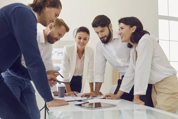 Gruppe junger lächelnder Büroangestellter Geschäftsleute tüftelt gemeinsam im Büro an einem neuen Projekt — Stockfoto