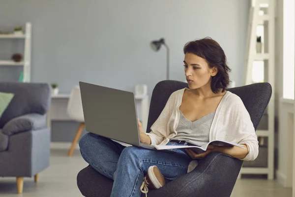 Frau sitzt mit Laptop und Notebook und chattet mit jemandem während eines Videogesprächs — Stockfoto