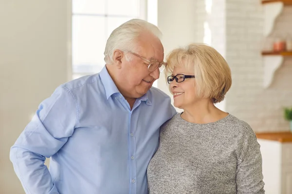 Alter Mann und alte Frau umarmen sich und genießen die gemeinsame Zeit zu Hause. — Stockfoto