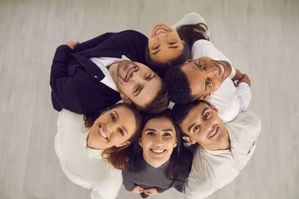 Skupina šťastných různorodých podnikatelů stojí v kruhu a dívá se do kamery — Stock fotografie
