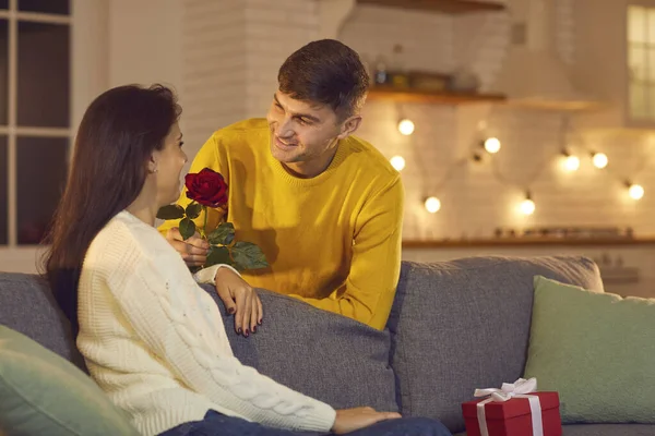 Sorrindo jovem namorado ou marido dando flores para sua namorada mulher ou esposa para o dia dos namorados — Fotografia de Stock