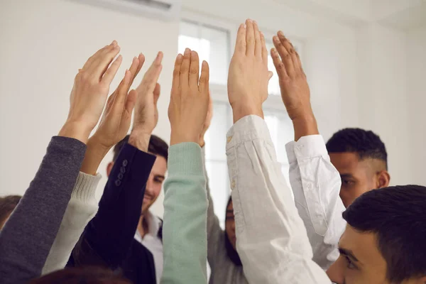 Equipe de jovens levantando as mãos no ar, votando por uma boa ideia ou mostrando solidariedade — Fotografia de Stock