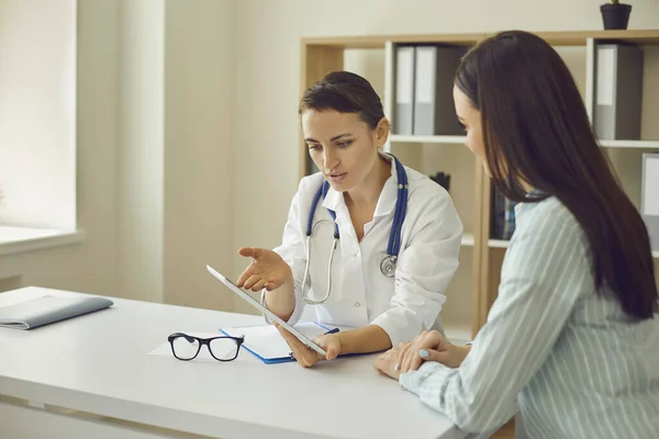 Hasta ile iletişim kuran ve kliniğe gittiği sırada araştırma sonuçlarını gösteren kadın doktor terapisti. — Stok fotoğraf