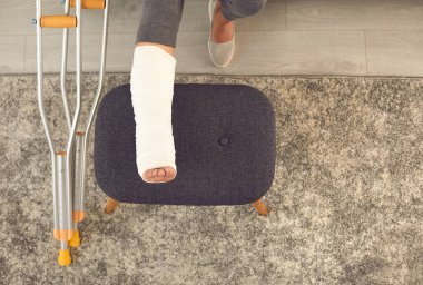 Ayak bileği ya da ayak kırığı olan hasta rehabilitasyon görüyor ve evinde dinleniyor.