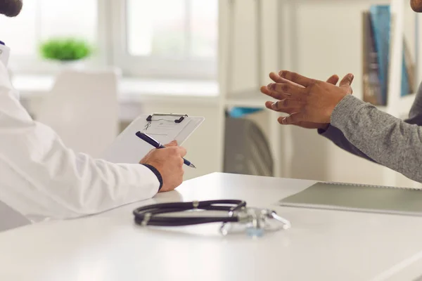 Paciente diciéndole al doctor acerca de sus síntomas y pidiéndole que le recete algún medicamento —  Fotos de Stock